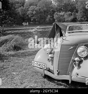 Mit dem Ford V8 unterwegs bin Siehe zum Zelten, Deutschland 1930er Jahre. Mit einem Ford V8 am Ufer eines Sees und ein Zelt, Deutschland 1930. Stockfoto