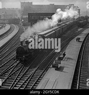 Ein Personenzug, gezogen von einer Lokomotive der Baureihe 74, verlässt den Hauptbahnhof Hamburg, Deutschland 1930er Jahre. Ein Zug mit Dampflokomotive der Baureihe 74 ab Hauptbahnhof Hamburg, Deutschland 1930. Stockfoto