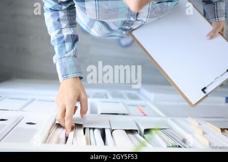 Frau nimmt Geschäftsdokumente aus der Nähe des Kabinetts heraus Stockfoto