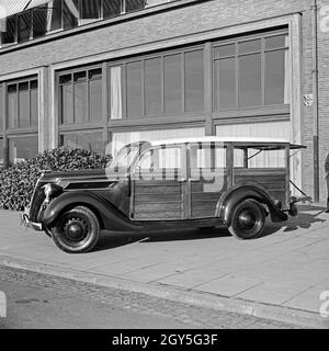 Ein Ford V8 Modell 68 mit Holzverkeidung der Firmenzentrale der Ford Werke in Köln Niehl, Deutschland 1930er Jahre. Ein Ford V8-Modell 68 van mit Holz Folien vor der Deutschen Ford Zentrale in Köln, Deutschland 1930. Stockfoto