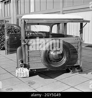 Ein Ford V8 Modell 68 mit Holzverkeidung der Firmenzentrale der Ford Werke in Köln Niehl, Deutschland 1930er Jahre. Ein Ford V8-Modell 68 mit Holz Folien vor der Deutschen Ford Zentrale in Köln, Deutschland 1930. Stockfoto