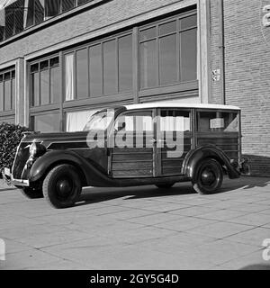 Ein Ford V8 Modell 68 mit Holzverkeidung der Firmenzentrale der Ford Werke in Köln Niehl, Deutschland 1930er Jahre. Ein Ford V8-Modell 68 van mit Holz Folien vor der Deutschen Ford Zentrale in Köln, Deutschland 1930. Stockfoto