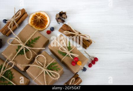 Weihnachtskomposition. Weihnachtsgeschenke, Tannenzapfen, Tannenzweige auf weißem Holzhintergrund. Stockfoto