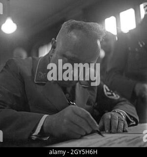 Reichsleiter Robert Ley leistet eine Unterschrift, Deutschland 1930er Jahre. Reichsleiter Robert Ley unterzeichnet ein Dokument, Deutschland 1930er Jahre. Stockfoto