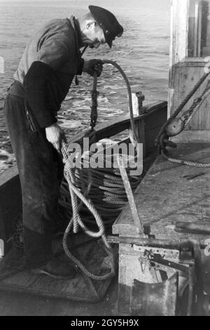 Ein Hochseefischer bei der Arbeit ein Deck, Deutschland 1930er Jahre. Ein tiefes Meer Fischer Arbeiten an Deck, Deutschland 1930. Stockfoto