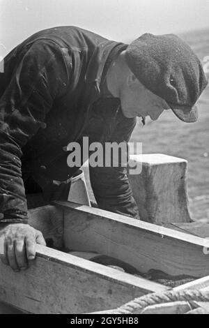 Ein Hochseefischer bei der Arbeit ein Deck, Deutschland 1930er Jahre. Ein tiefes Meer Fischer Arbeiten an Deck, Deutschland 1930. Stockfoto