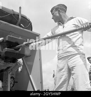 Original-Bildunterschrift: Dienst des Matrosen: Beim Reinigen der Geschütze ein Bord eines Torpedoboots, Deutschland 1940er Jahre. Sailor's Pflicht: Reinigung der eine Kanone von einem Torpedoboot, Deutschland 1940. Stockfoto