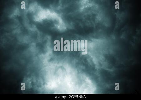 Dicke, dunkelschwarze Sturmwolken bedecken den Himmel bei Sonnenuntergang im Sommer mit einem Sturm mit Orkangeschwindigkeit, der kurz vor dem Gewitter Kalbaishakhi Bordoisila weht Stockfoto