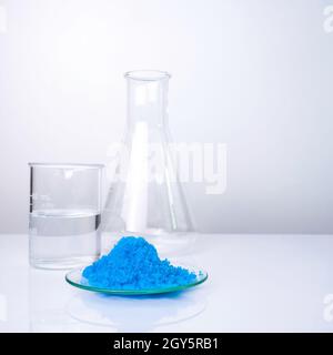 Nahaufnahme anorganischer Chemikalien auf weißem Labortisch. Kupfer(II)-Sulfat, Alkohol. Chemische Zutat für Kosmetika und Körperpflegeprodukte. Stockfoto