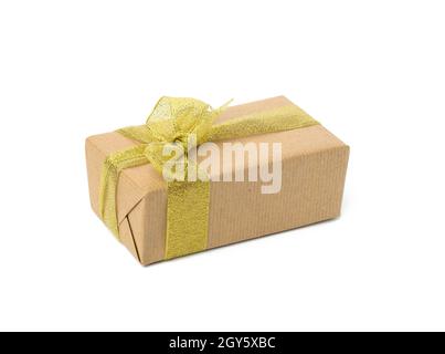 Rechteckige Box in braunem Kraftpapier und goldenem Band verpackt. Geschenk isoliert auf weißem Hintergrund Stockfoto