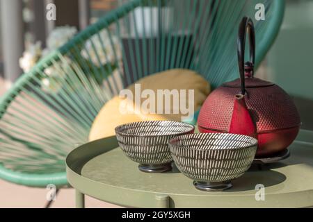 Elegante Ecke einer Terrasse eines modernen Hauses mit zwei Sesseln und einem chinesischen Tee mit zwei Tassen. Sonniger Sommertag Stockfoto