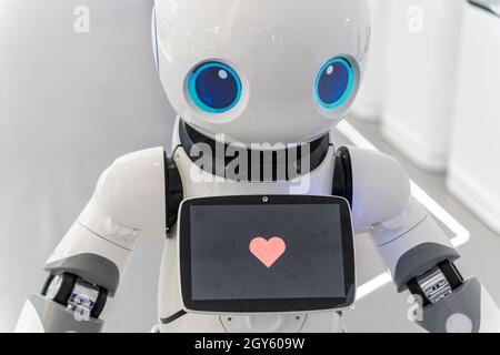 Roboter zeigen Herzform auf dem Bildschirm, um die Liebe zur Menschheit zu zeigen. Stockfoto