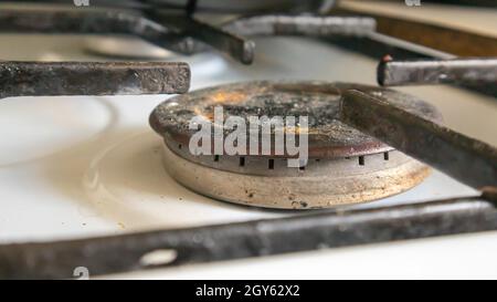 Schmutziger Gasherd in der Küche zum Kochen mit Pflanzenölflecken und verbrannten Speisereste auf der Oberfläche, Nahaufnahme. Selektiver Fokus. Mit Fett überzogene g Stockfoto