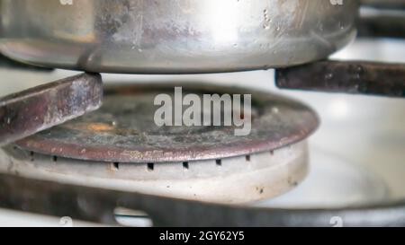 Schmutziger Gasherd in der Küche zum Kochen mit Pflanzenölflecken und verbrannten Speisereste auf der Oberfläche, Nahaufnahme. Selektiver Fokus. Mit Fett überzogene g Stockfoto