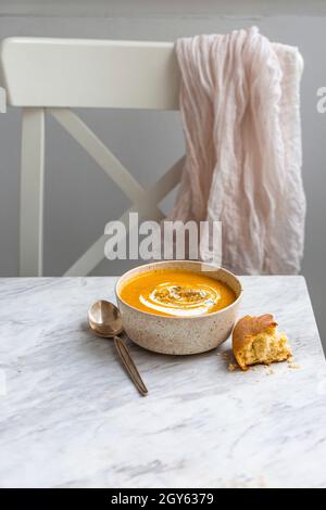 Schüssel mit Kürbissuppe auf einer weißen Marmoroberfläche Stockfoto