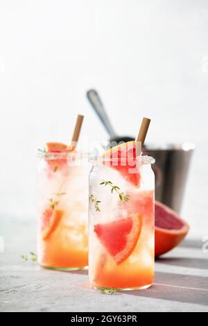 Trendige Sommergetränke mit Grapefruit und Rosmarin aus nächster Nähe. Erfrischende hausgemachte Cocktails, Sommergetränke, selektiver Fokus. Sonnige Schatten am Tag Stockfoto