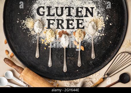 Glutenfrei in Mehl auf Backblech, Küchengeräte und Löffel aus verschiedenen glutenfreien Mehl (Mandelmehl, Buchweizenmehl, Reisfl Stockfoto