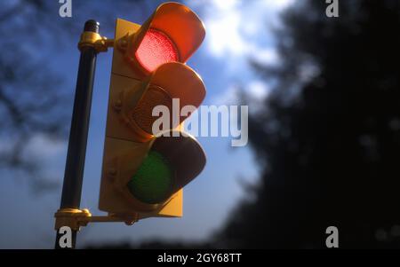 Vertikale Außenampel mit blauem Himmel und Bäumen um das Hotel herum. Verkehrskontrollkonzept mit geringer Schärfentiefe. Stockfoto