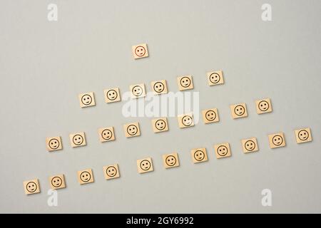 Holzblöcke mit Figuren auf grauem Hintergrund, hierarchische Organisationsstruktur des Managements, effektives Managementmodell in der Organisation, Stockfoto