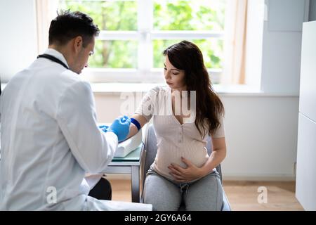 Vorgeburtliche Untersuchungen. Arzt Zieht Blutprobe Von Einer Schwangeren Ab Stockfoto