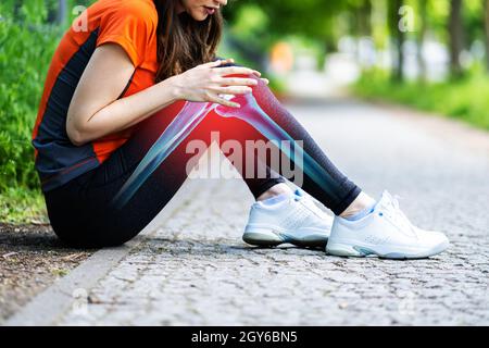 Weibliche Jogger mit Schmerzen im Knie Stockfoto
