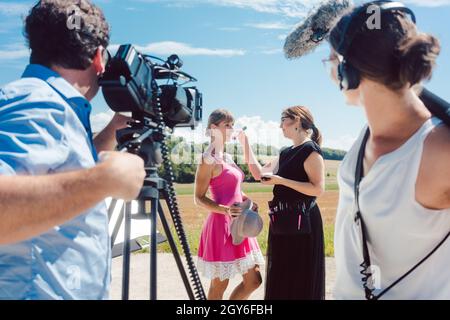 Videoaufnahmen mit Crew, Make-up Artist und Model am Set Stockfoto