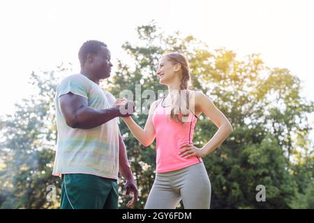 Schwarz-weißes Paar, das für sein Outdoor-Training Motivation für Sport bekommt Stockfoto