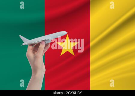 Flugzeug in der Hand mit der Nationalflagge von Kamerun Reise nach Kamerun. Stockfoto