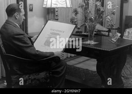 Der Inhaber des Musterbetriebs Wilhelm Plum mit thunfischwadenfänger Urkunde, Deutsches Reich 1941. Eigentümer der Modellpflanze Wilhelm Pflaume mit seinem Zertifikat, Deutschland 1941. Stockfoto