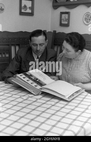 Die Inhaber des Musterbetriebs Wilhelm Pflaume mit einem Fotoalbum, Deutsches Reich 1941. Eigentümer der Modellpflanze Wilhelm Pflaume mit einem Fotoalbum, Deutschland 1941. Stockfoto