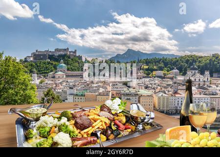 Salzburg Stadt mit gastronomischem Erlebnis der typischen österreichischen Küche und Wein gegen die Innenstadt in Österreich Stockfoto