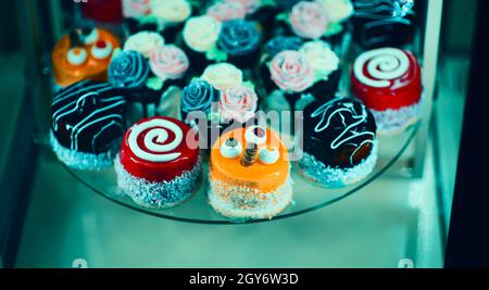 Nahaufnahme verschiedener süßer Cupcakes, selektiv fokussiert, vor einem bokehen Hintergrund. Stockfoto