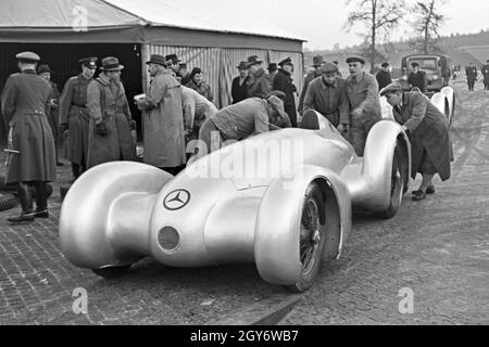 Vorsichtig wird der Mercedes Benz W 125 zum Start des Weltrekordversuchs geschoben, Deutschland 1930er Jahre. Vorsichtig den Mercedes Benz W125 ist auf den Beginn der Weltrekord Versuch schob, Deutschland 1930. Stockfoto