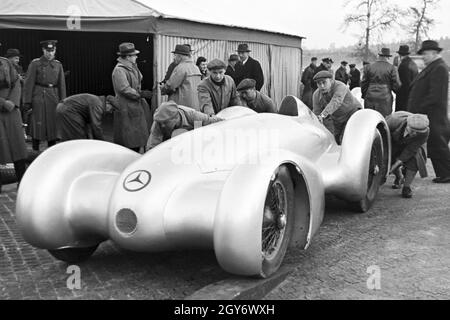 Vorsichtig wird der Mercedes Benz W 125 zum Start des Weltrekordversuchs geschoben, Deutschland 1930er Jahre. Vorsichtig den Mercedes Benz W125 ist auf den Beginn der Weltrekord Versuch schob, Deutschland 1930. Stockfoto