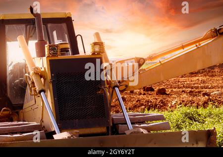 Selektiver Fokus auf Bulldozer auf unscharfen Hintergrund einer Baggerlader auf der Baustelle. Aushubfahrzeug. Hydraulikarm. Landentwicklungsgeschäft. Bulld Stockfoto