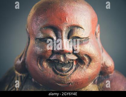 Traditionelle Holzstatue des chinesischen Buddha isoliert auf dunklem Hintergrund Stockfoto