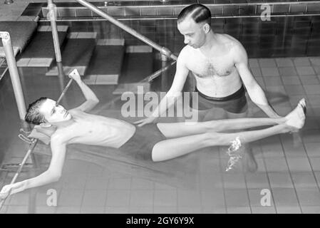 Ein Patient bei der Unterwasserbehandlung mit einem Bademeister, Deutschland 1930er Jahre. Ein Patient in einem Heilbad, Deutschland 1930. Stockfoto