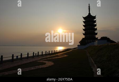 Der Park wurde als Aussichtsplatz für die Gezeitenströmung an der Mündung des Qiantang River genutzt. Nördliches Ufer des Qiantang Flusses bei Hangzhou bei Sonnenuntergang. Stockfoto