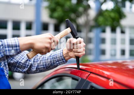 Schlosser Mit Keil-Werkzeug Zum Öffnen Der Gesperrten Fahrzeugtür Stockfoto