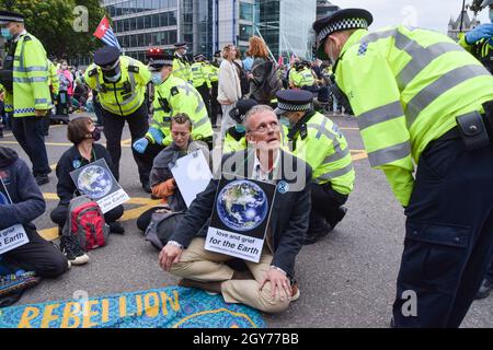 Die Polizei bewegt Demonstranten in Tower Hill. Die Demonstranten des Extinction Rebellion marschierten im Rahmen ihrer zweiwöchigen Kampagne „Impossible Rebellion“ zur Tower Bridge. London, Großbritannien. August 2021. Stockfoto
