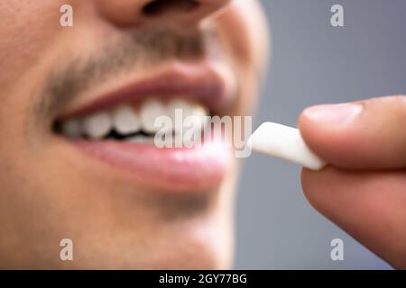 Mann, Der Nikotin-Gum Verwendet, Um Das Rauchen Zu Beenden. Nikotinersatztherapie Stockfoto