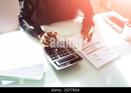 Public African Tax Accountant Using Calculator. Finanzbuch Stockfoto