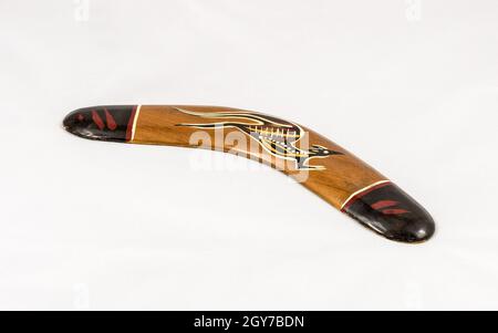 In braunem Holz dekorierter australischer Bumerang isoliert auf weißem Hintergrund Stockfoto