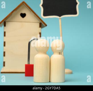 Hölzerne Familienfiguren, Modellhaus. Immobilienkauf, Mietkonzept. Umzug in neue Wohnungen, Nahaufnahme Stockfoto