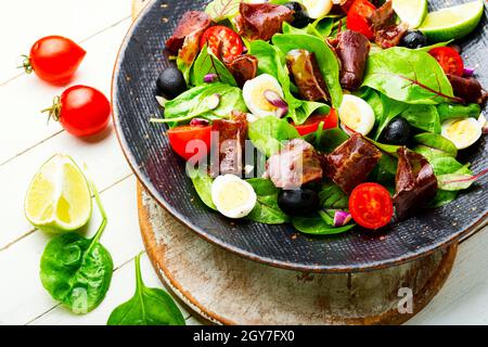 Diätsalat aus Mangold, Wachteleiern, Tomaten und Ruckeys. Salat mit Jamon und Gemüse. Stockfoto