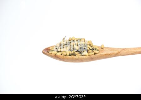 Getreidegetränk im Holzlöffel isoliert auf weißem Hintergrund. Stockfoto