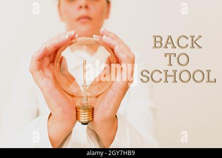 Inspiration mit Zeichen Zurück zur Schule, Wort geschrieben auf ist die Zeit in Bezug auf den Beginn eines neuen Schuljahres Dame im Outfit hält Lampe mit zwei Stockfoto