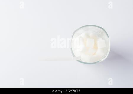Draufsicht Glas voll von weißen Zucker Würfel süße Lebensmittel-Zutat, Studio Schuss isoliert auf weißem Hintergrund, Gesundheit hohes Blutrisiko von Diabetes und Calori Stockfoto