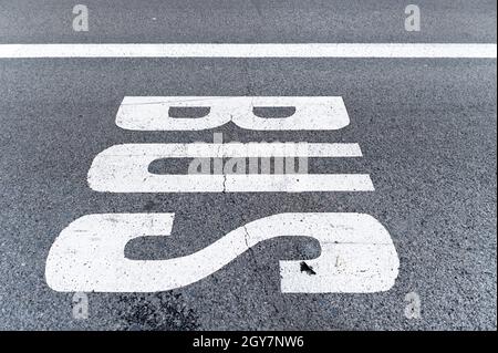Busschild auf dem Bürgersteig einer Straße gemalt, können Sie die Textur des Asphalts mit einer rissigen Linie zu sehen. Signal- und Stadtkonzept Stockfoto