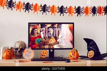 Computer mit Halloween-Party-Desktop-Hintergrund auf dekorierten Schreibtisch stehen Stockfoto